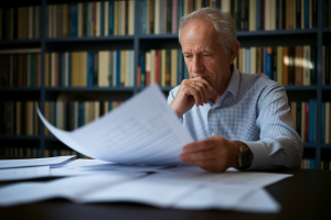 homme-age-bureau-livres-documents